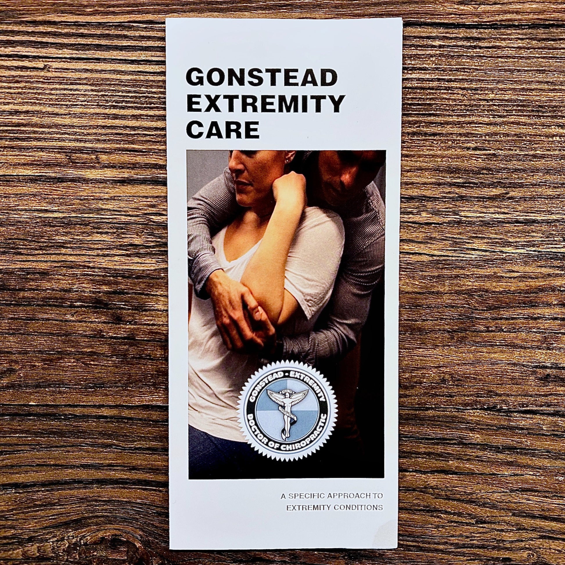 Brochure titled 'Gonstead Extremity Care' on a wooden surface